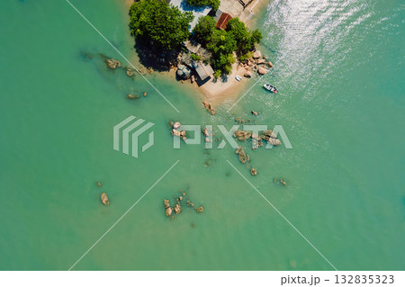 Drone view of shoreline with turquoise water, rocky coast and dense green jungle 132835323