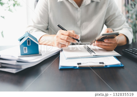Real estate agent agree to buy home to clients agency office. House model, real estate agent, customer discussing for contract to buy house, insurance, loan real estate background. Concept agreement. Real estate agent agree to buy home to clients agency office. House model, real estate agent, customer discussing for contract to buy house, insurance, loan real estate background. Concept agreement. 132835519