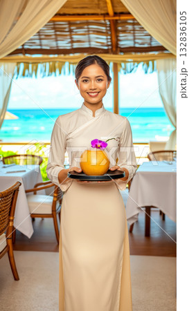 Beautiful Asian woman waiter carrying on tray drinks while working in restaurant. 132836105