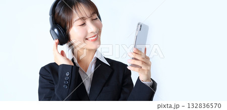 スマホで音楽を聴く女性会社員イメージ 132836570