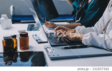 Group of doctors attending seminar in hospital lecture hall with senior physician giving medical presentation and professional training session on healthcare practices Group of doctors attending seminar in hospital lecture hall with senior physician giving medical presentation and professional training session on healthcare practices 132837382