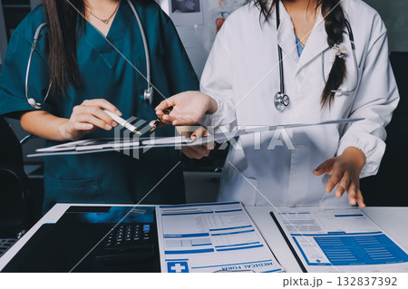 Group of doctors attending seminar in hospital lecture hall with senior physician giving medical presentation and professional training session on healthcare practices 132837392