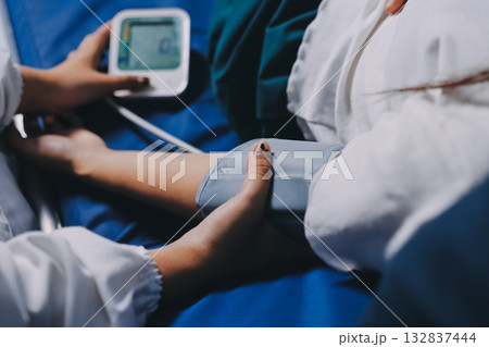 Nurse measuring blood pressure of elderly woman at table, closeup. Assisting senior generation Nurse measuring blood pressure of elderly woman at table, closeup. Assisting senior generation 132837444