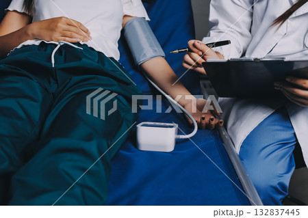 Nurse measuring blood pressure of elderly woman at table, closeup. Assisting senior generation 132837445