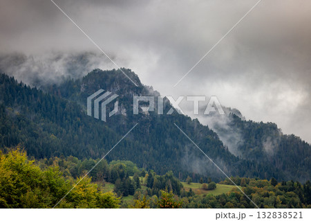 Misty mountain landscape with lush green forests and towering peaks shrouded in clouds creating a serene and atmospheric view. The Mala Fatra national park in Slovakia, Europe. 132838521