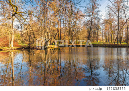 Autumn Reflections: Still lake mirrors the surrounding trees in their fall colors, creating a serene and beautiful landscape. Autumn Reflections: Still lake mirrors the surrounding trees in their fall colors, creating a serene and beautiful landscape. 132838553