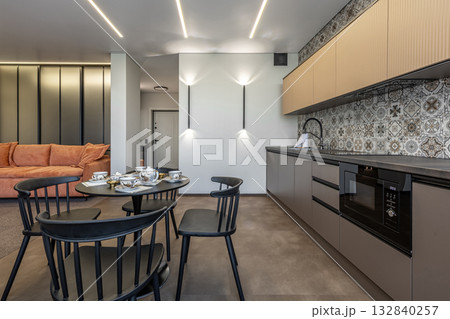 Modern Kitchen Interior with Patterned Tiles and Orange Sofa 132840257