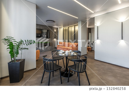 Modern Living Room with Orange Sofa and Black Dining Set 132840258