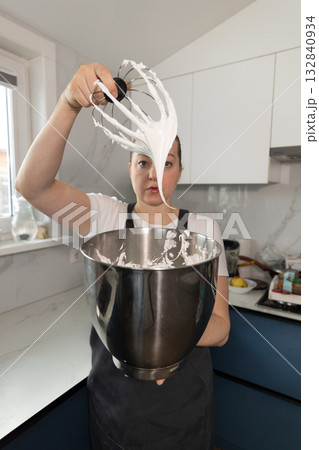 Pastry Chef Preparing Meringue in a Modern Kitchen for Delicious Desserts Pastry Chef Preparing Meringue in a Modern Kitchen for Delicious Desserts 132840934