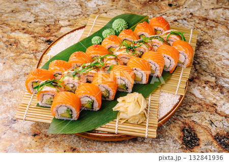 Colorful sushi laid out on a wooden platter with wasabi and ginger Colorful sushi laid out on a wooden platter with wasabi and ginger 132841936
