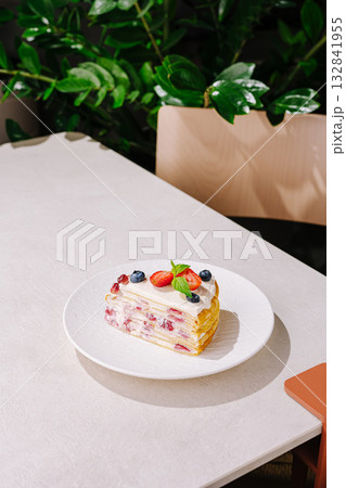 Delicious dessert served on a white plate in a cozy cafe setting Delicious dessert served on a white plate in a cozy cafe setting 132841955