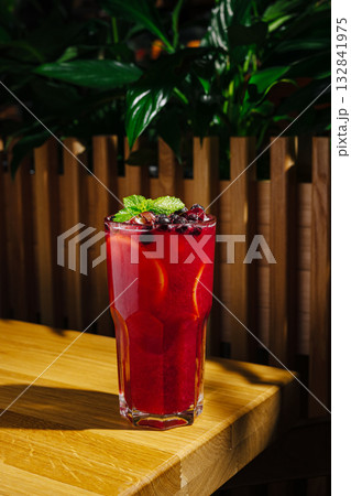 Refreshing crimson drink with mint and berries on wooden table Refreshing crimson drink with mint and berries on wooden table 132841975