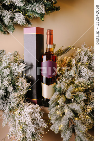 Festive display of wine bottle and holiday greenery with lights Festive display of wine bottle and holiday greenery with lights 132842069