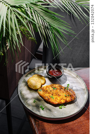 Delicious meal served on a plate with side potatoes and sauce in a cozy setting Delicious meal served on a plate with side potatoes and sauce in a cozy setting 132842074