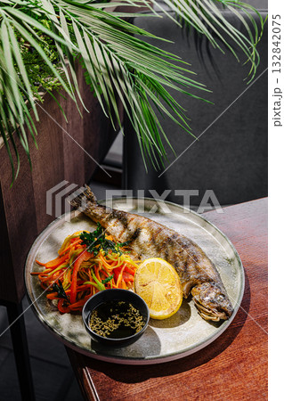 Freshly grilled fish served with colorful vegetable salad and lime Freshly grilled fish served with colorful vegetable salad and lime 132842075