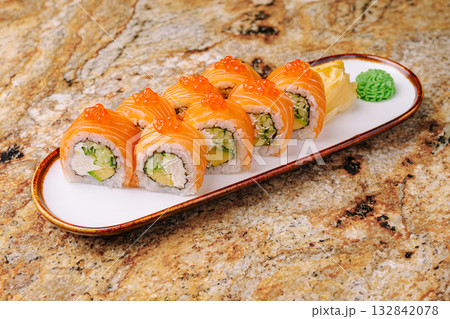 Fresh salmon sushi rolls served on a white plate with wasabi and ginger Fresh salmon sushi rolls served on a white plate with wasabi and ginger 132842078