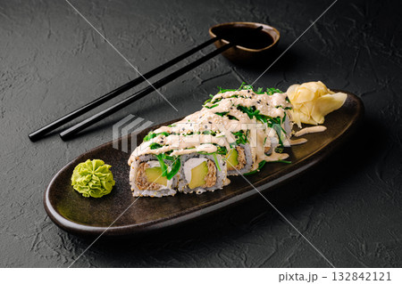 Sushi roll served on a dark plate with wasabi and pickled ginger Sushi roll served on a dark plate with wasabi and pickled ginger 132842121