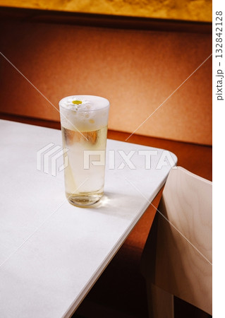 Refreshing drink served in a tall glass on a table with warm lighting 132842128