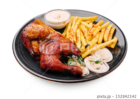 Crispy grilled chicken with fries and sauce served on a black plate Crispy grilled chicken with fries and sauce served on a black plate 132842142