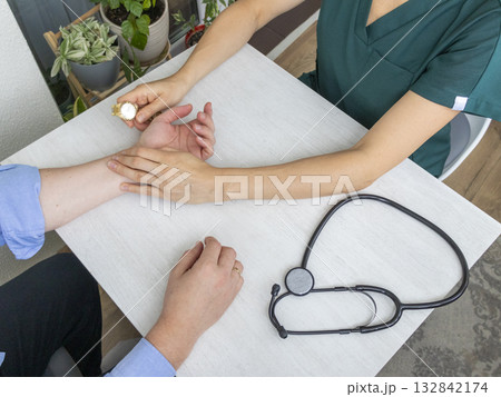 Female doctor measuring the pulse of the patient Female doctor measuring the pulse of the patient 132842174
