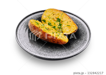 Baked potato served on a black plate with fresh herbs Baked potato served on a black plate with fresh herbs 132842217