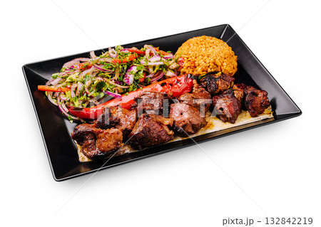 Delicious grilled meat served with rice and fresh salad in a vibrant dish 132842219
