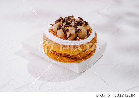 Delicious dessert with cream and chocolate shavings on a white background Delicious dessert with cream and chocolate shavings on a white background 132842294