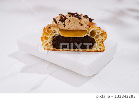 Chocolate dessert with creamy filling and crispy pastry layers on display 132842295