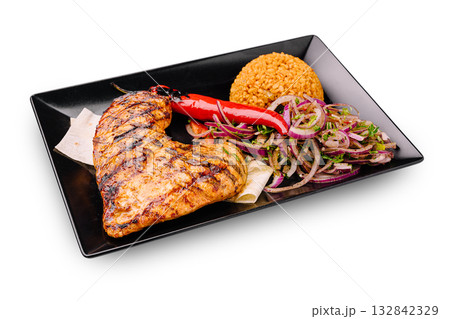Grilled chicken breast with rice and vegetables on a black plate 132842329