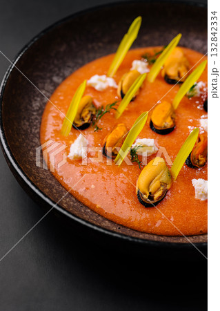 Delicious seafood dish served on a dark plate at a modern restaurant Delicious seafood dish served on a dark plate at a modern restaurant 132842334