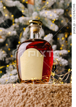 Holiday spirit in a decorative bottle with festive backdrop Holiday spirit in a decorative bottle with festive backdrop 132842346