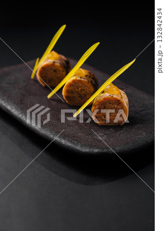 Innovative dish featuring unique flavors served on a dark platter 132842434
