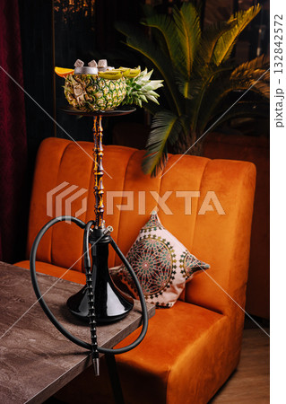 Hookah with fruits served on a table in a cozy lounge setting at night Hookah with fruits served on a table in a cozy lounge setting at night 132842572