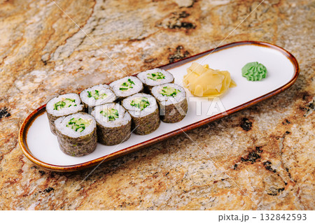 Sushi rolls served on a plate with wasabi and ginger on a marble table 132842593