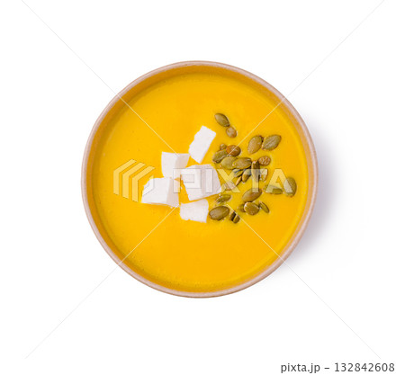 Bright orange soup with cheese and seeds in a simple bowl 132842608