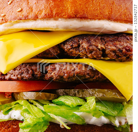 Juicy double cheeseburger with fresh toppings and soft bun in bright light Juicy double cheeseburger with fresh toppings and soft bun in bright light 132842717