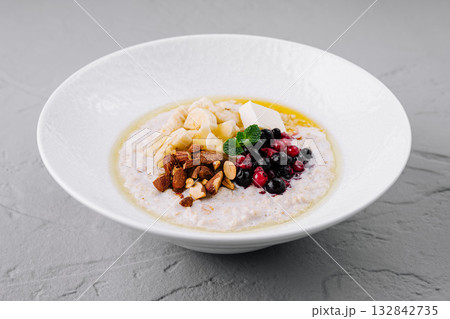 Oatmeal porridge with berries, banana and almonds for healthy breakfast 132842735
