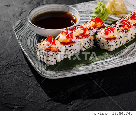 Gourmet sushi roll with toppings on slate background Gourmet sushi roll with toppings on slate background 132842740