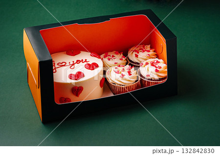 Celebration cake and cupcakes with flowers arranged for special 132842830
