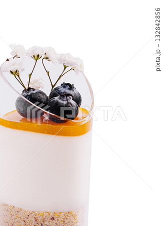 Delicious layered dessert with fruit and flowers in elegant presentation 132842856