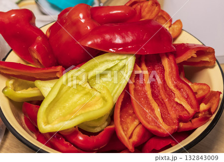 Green and red capsicums, cut and washed in the metallic bawl 132843009