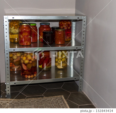 Assembled galvanized steel shelving unit with jar with different types of pickles and preserves on it. Assembled galvanized steel shelving unit with jar with different types of pickles and preserves on it. 132843414