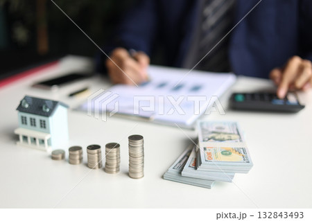 Investing in Real Estate, Real estate agent or investor calculating, planning, analyzing financial data for property investment. Themes of saving, investing, financial aspects of purchasing a home. Investing in Real Estate, Real estate agent or investor calculating, planning, analyzing financial data for property investment. Themes of saving, investing, financial aspects of purchasing a home. 132843493