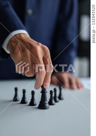Businessman wearing suit, playing chess game. Business strategy, leadership, planning and management concept. 132843520