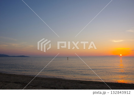 兵庫県南あわじ市　慶野松原海水浴場から小豆島に沈む夕陽を望む 132843912