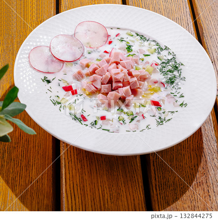 Delicious cold soup with diced ham and fresh radishes garnished beautifully 132844275