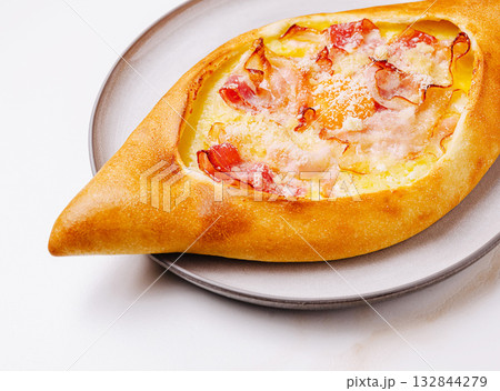 Delicious khachapuri served on a plate close-up with melted cheese Delicious khachapuri served on a plate close-up with melted cheese 132844279