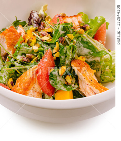 Fresh mixed salad with grilled chicken and roasted pistachios served in a bowl Fresh mixed salad with grilled chicken and roasted pistachios served in a bowl 132844308