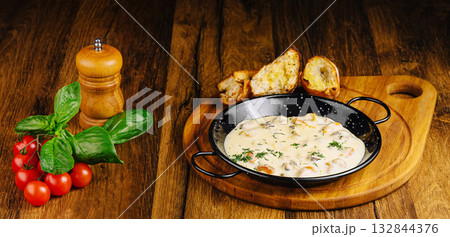 Delicious creamy mussels dish served with fresh herbs and bread 132844376