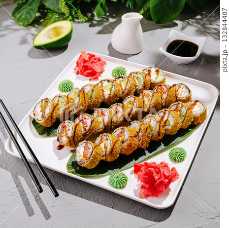 Delicious sushi rolls served on a platter with side condiments 132844407